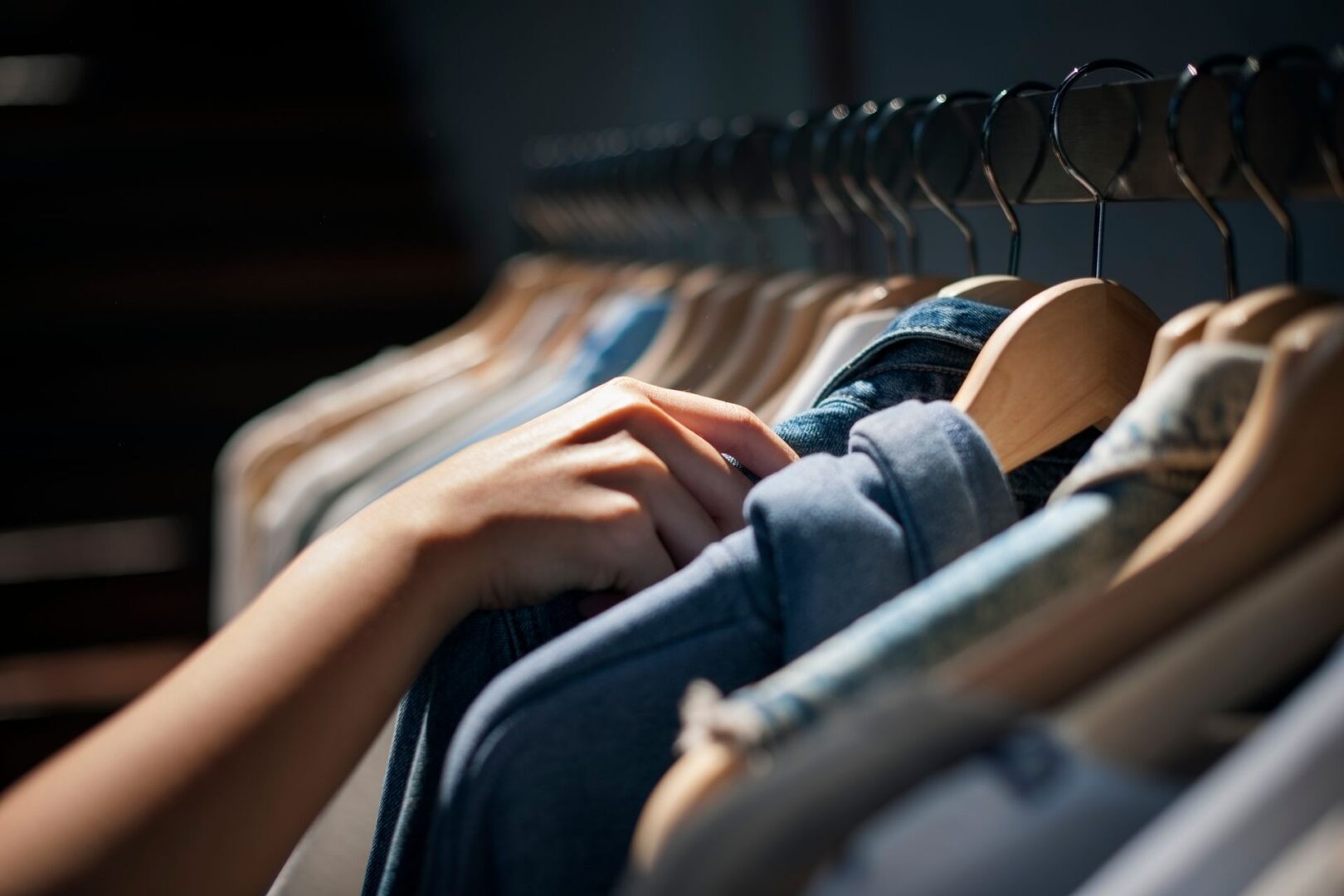 Person choosing clothing from hangers