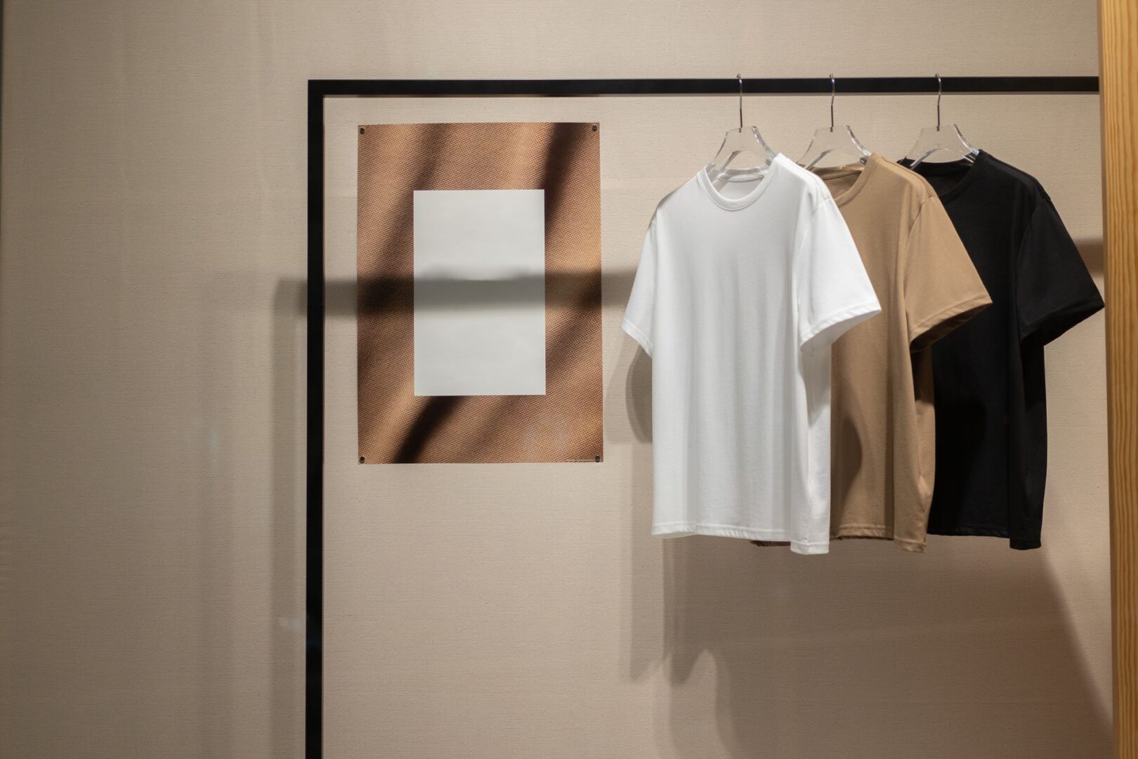 Three shirts on hangers, neutral tones