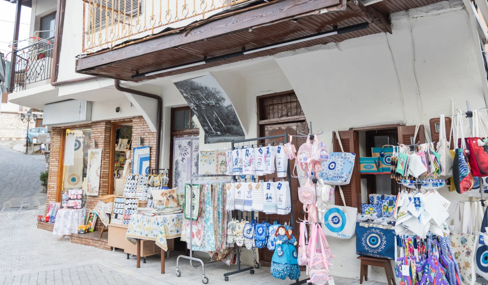 Souvenirs and textiles hanging outside a shop.